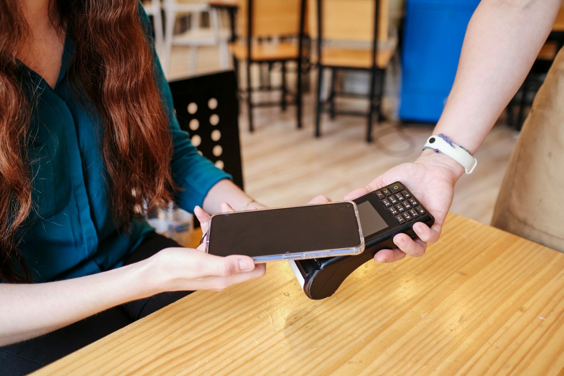 Unrecognizable woman making a contactless smartphone payment.